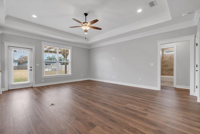 empty room with dark hardwood / wood-style flooring, a raised ceiling, ceiling fan, and crown molding