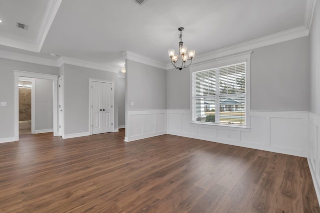 unfurnished room featuring dark hardwood / wood-style flooring, an inviting chandelier, and crown molding