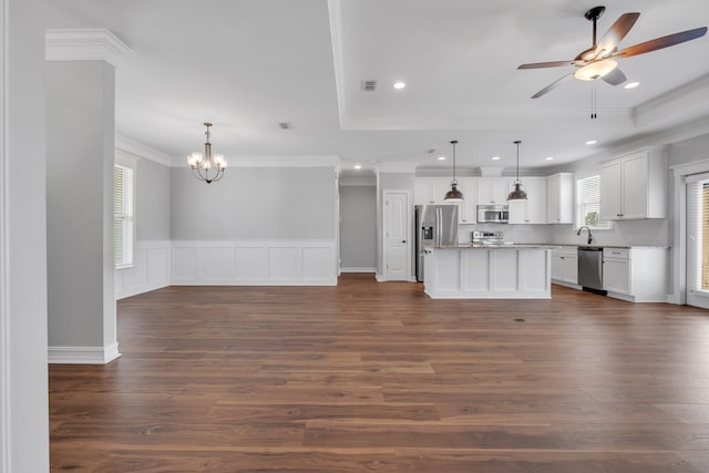 kitchen featuring appliances with stainless steel finishes, ceiling fan with notable chandelier, white cabinets, a kitchen island, and hanging light fixtures