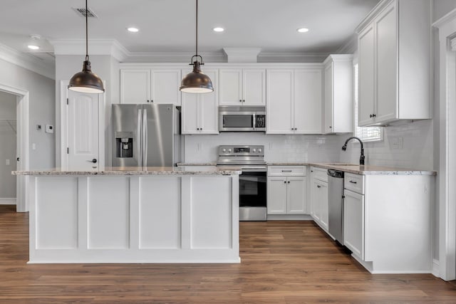 kitchen with sink, decorative light fixtures, a kitchen island, white cabinetry, and stainless steel appliances