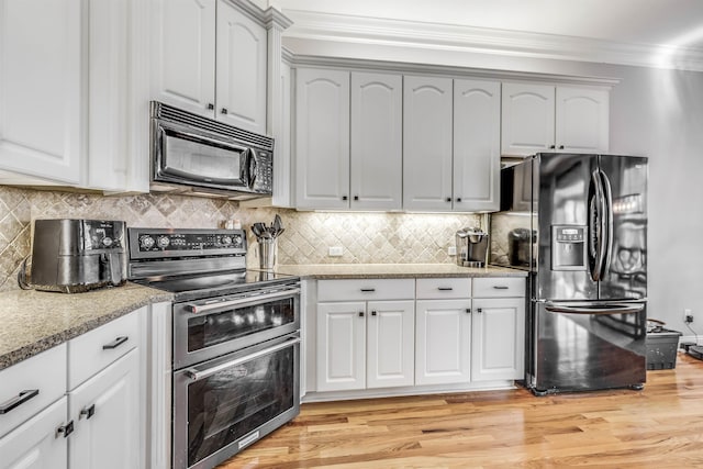832 Eagle View Dr, Tallahassee, FL 32311 - kitchen featuring black appliances, crown molding, light stone countertops, light wood-style flooring, and tasteful backsplash