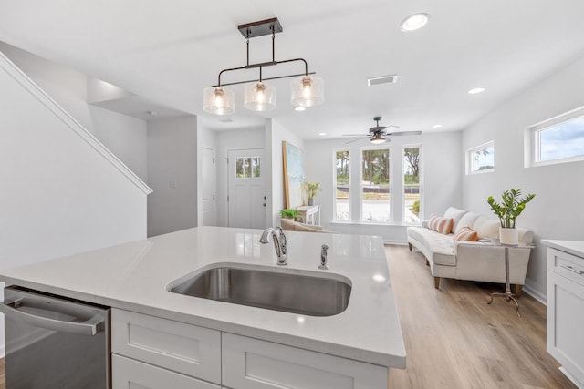 kitchen featuring pendant lighting, dishwasher, white cabinets, sink, and ceiling fan