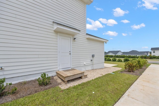 view of exterior entry featuring a yard