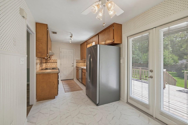 2903 Whirlaway Trl, Tallahassee, FL 32309 - kitchen featuring appliances with stainless steel finishes, brown cabinets, light marble finish flooring, light countertops, and ceiling fan