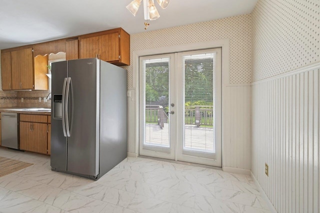 2903 Whirlaway Trl, Tallahassee, FL 32309 - kitchen with appliances with stainless steel finishes, french doors, light marble finish floors, and brown cabinetry
