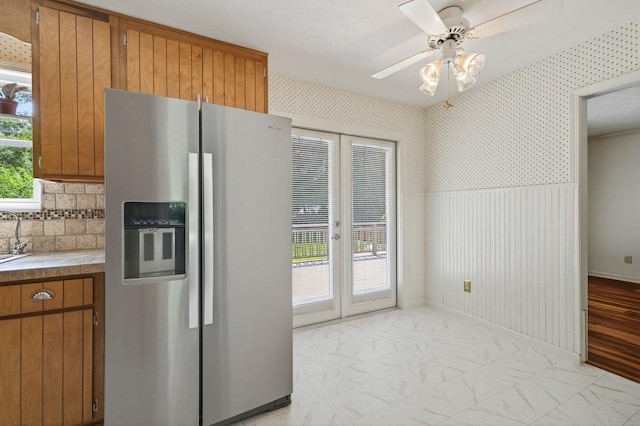 2903 Whirlaway Trl, Tallahassee, FL 32309 - kitchen with stainless steel fridge with ice dispenser, brown cabinetry, light countertops, a ceiling fan, and french doors