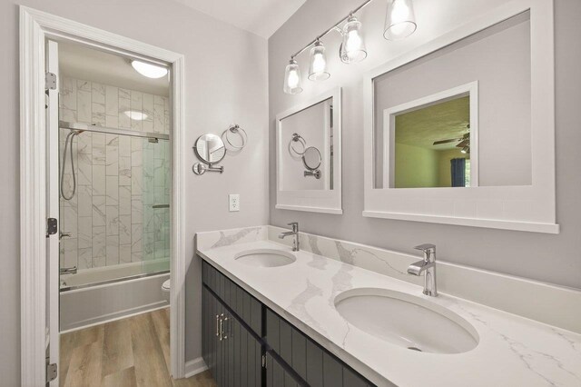 2903 Whirlaway Trl, Tallahassee, FL 32309 - bathroom with double vanity, wood finished floors, toilet, and bath / shower combo with glass door
