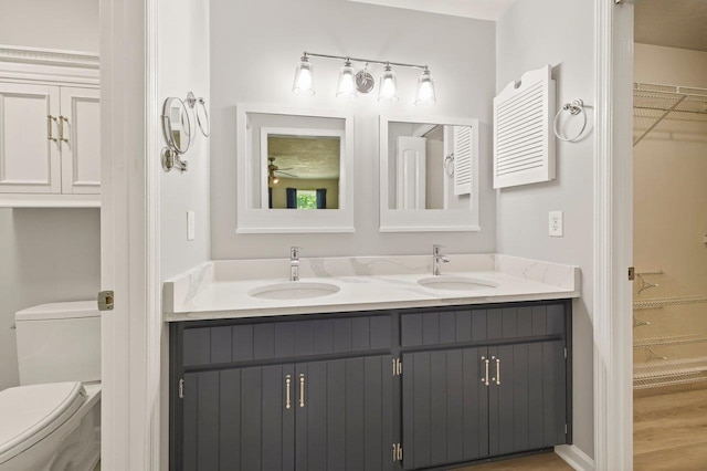 2903 Whirlaway Trl, Tallahassee, FL 32309 - bathroom featuring double vanity, a walk in closet, toilet, and wood finished floors