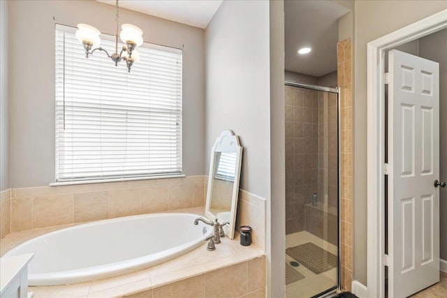 bathroom with plus walk in shower, a notable chandelier, and a healthy amount of sunlight