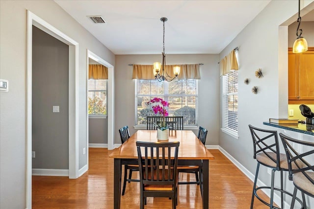 dining area with wood-type flooring and a chandelier