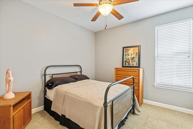 bedroom featuring light carpet, multiple windows, and ceiling fan