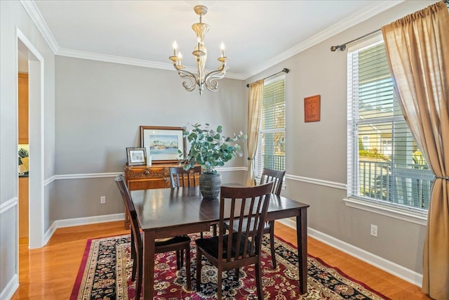 dining room with ornamental molding, a chandelier, and light wood-type flooring