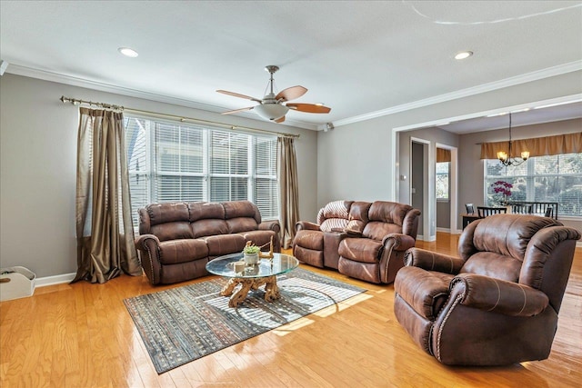 living room featuring ceiling fan with notable chandelier, light hardwood / wood-style flooring, and crown molding