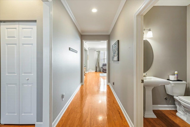 hall with crown molding and light hardwood / wood-style floors