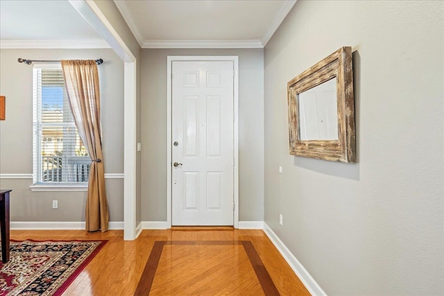 entryway with ornamental molding and hardwood / wood-style floors