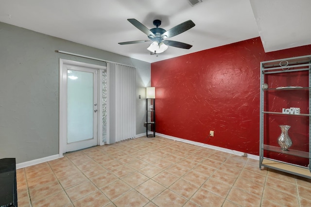 tiled empty room featuring ceiling fan