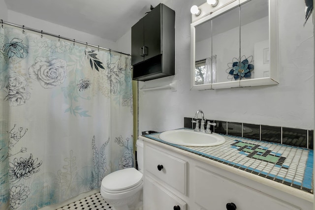 bathroom featuring vanity, tile patterned floors, and toilet