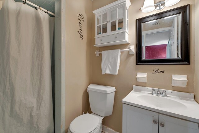 bathroom with walk in shower, vanity, and toilet