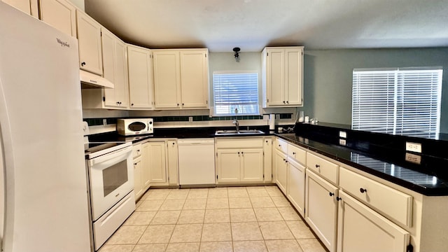 4417 Siesta Ct, Tallahassee, FL 32309 - kitchen featuring white appliances, a sink, under cabinet range hood, a peninsula, and light tile patterned floors