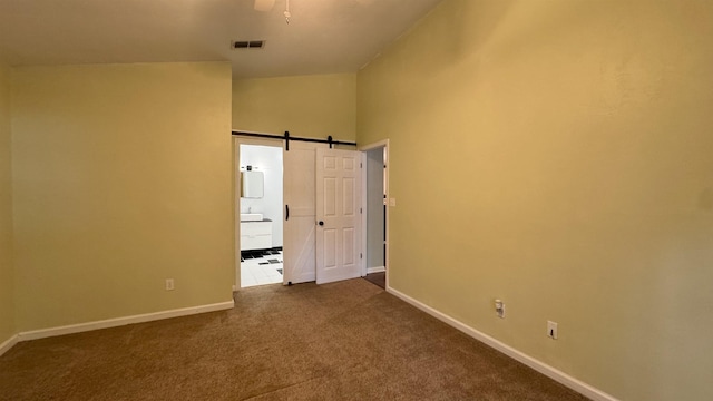 4417 Siesta Ct, Tallahassee, FL 32309 - empty room featuring a barn door, baseboards, dark colored carpet, and ceiling fan
