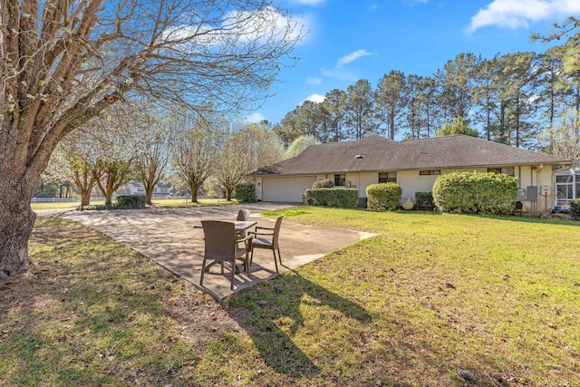 view of yard with concrete driveway and a garage