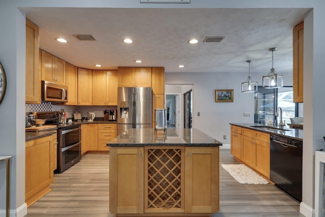 kitchen with visible vents, appliances with stainless steel finishes, light wood-type flooring, and a sink