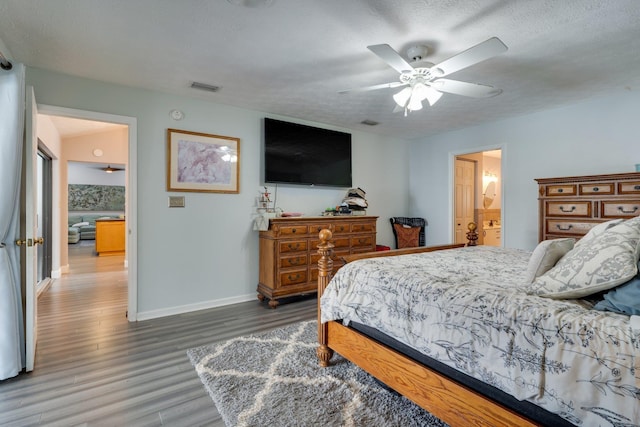 bedroom with visible vents, ceiling fan, baseboards, wood finished floors, and a textured ceiling