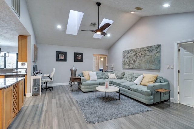 living room featuring visible vents, high vaulted ceiling, and light wood-style floors