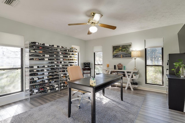 office area with visible vents, baseboards, wood finished floors, a textured ceiling, and a ceiling fan