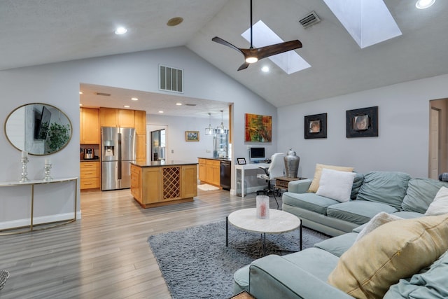 living room with visible vents, baseboards, a skylight, and light wood-style flooring