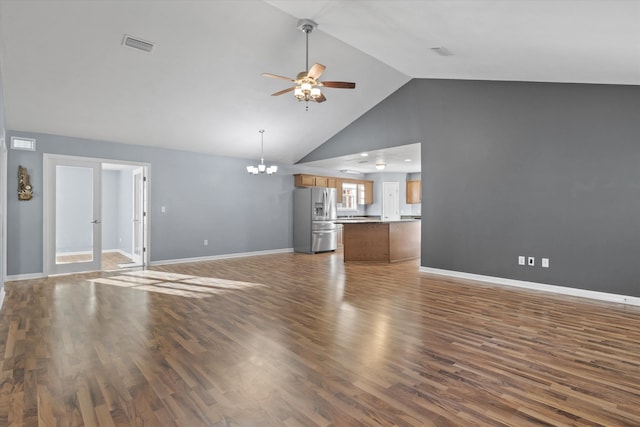 unfurnished living room with ceiling fan with notable chandelier, dark hardwood / wood-style flooring, and high vaulted ceiling