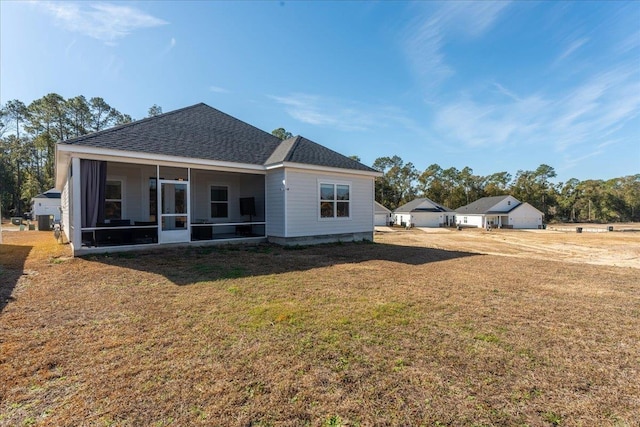 back of house featuring a yard and a sunroom