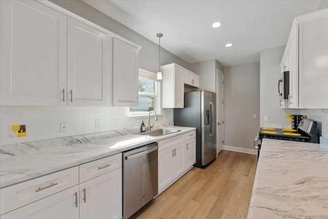 kitchen featuring decorative light fixtures, sink, white cabinets, backsplash, and stainless steel appliances