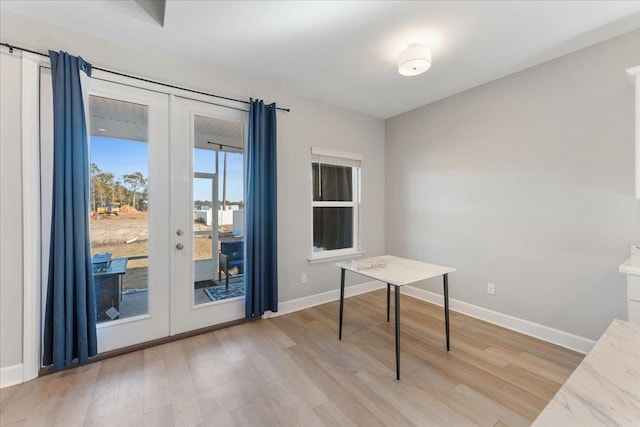 unfurnished office featuring french doors and light wood-type flooring