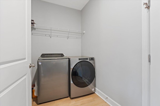 laundry room with light hardwood / wood-style flooring and independent washer and dryer