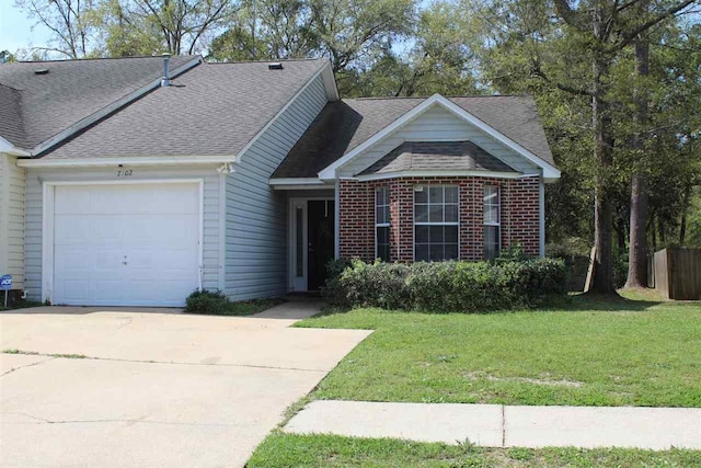 view of front of property featuring brick siding, roof with shingles, concrete driveway, an attached garage, and a front yard