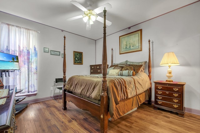 bedroom featuring hardwood / wood-style flooring, multiple windows, and ceiling fan