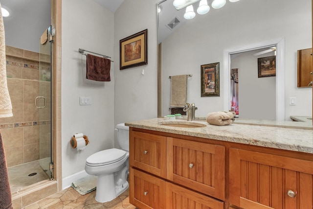 bathroom with toilet, vanity, and a shower with door