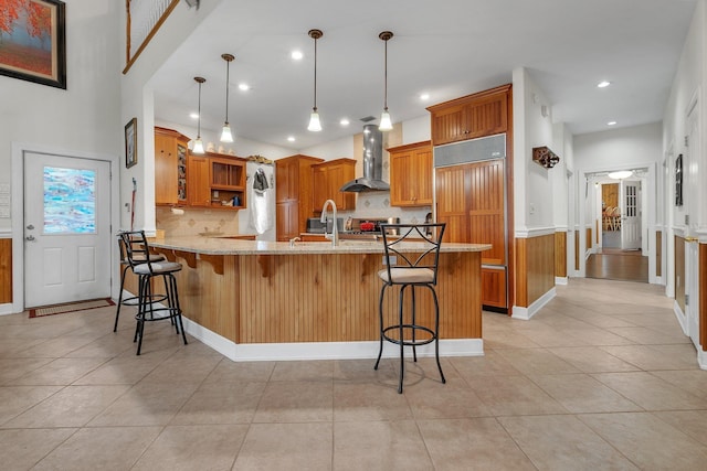 2875 Cooks Landing Rd, Quincy, FL 32351 - kitchen featuring wall chimney exhaust hood, a peninsula, open shelves, brown cabinetry, and backsplash