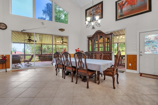 tiled dining space featuring a healthy amount of sunlight and a towering ceiling