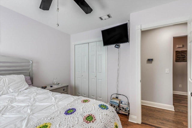 bedroom with dark hardwood / wood-style flooring, a closet, and ceiling fan