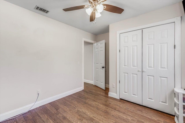 unfurnished bedroom with hardwood / wood-style floors, ceiling fan, and a closet