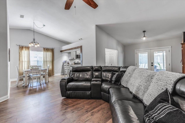 living room with vaulted ceiling, a healthy amount of sunlight, dark wood-type flooring, and french doors