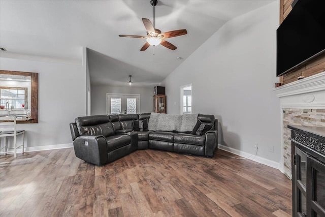 living room featuring hardwood / wood-style flooring, ceiling fan, a fireplace, and high vaulted ceiling