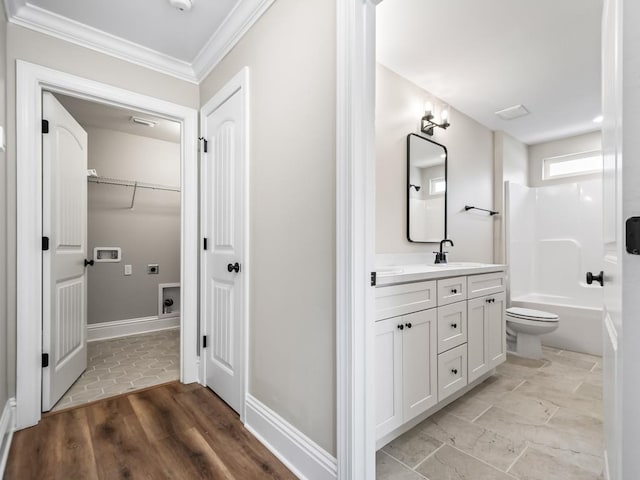 full bathroom featuring toilet, hardwood / wood-style floors, ornamental molding, vanity, and tub / shower combination