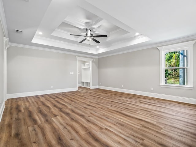 unfurnished bedroom featuring ornamental molding, hardwood / wood-style flooring, ceiling fan, and a tray ceiling