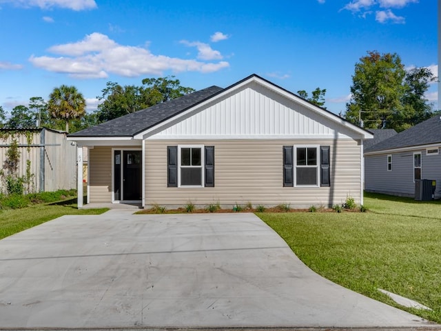 view of front of home with cooling unit and a front lawn