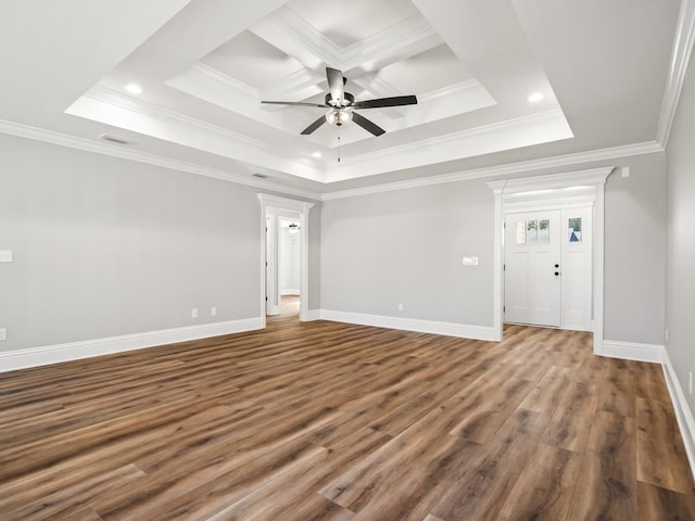 unfurnished room featuring a raised ceiling, dark hardwood / wood-style floors, crown molding, and ceiling fan