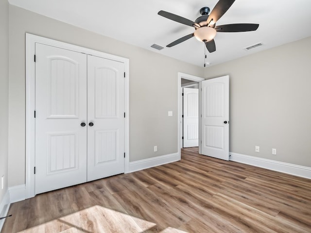 unfurnished bedroom featuring light hardwood / wood-style floors, ceiling fan, and a closet