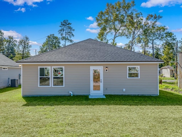 view of front of home featuring cooling unit, a front yard, and a storage unit